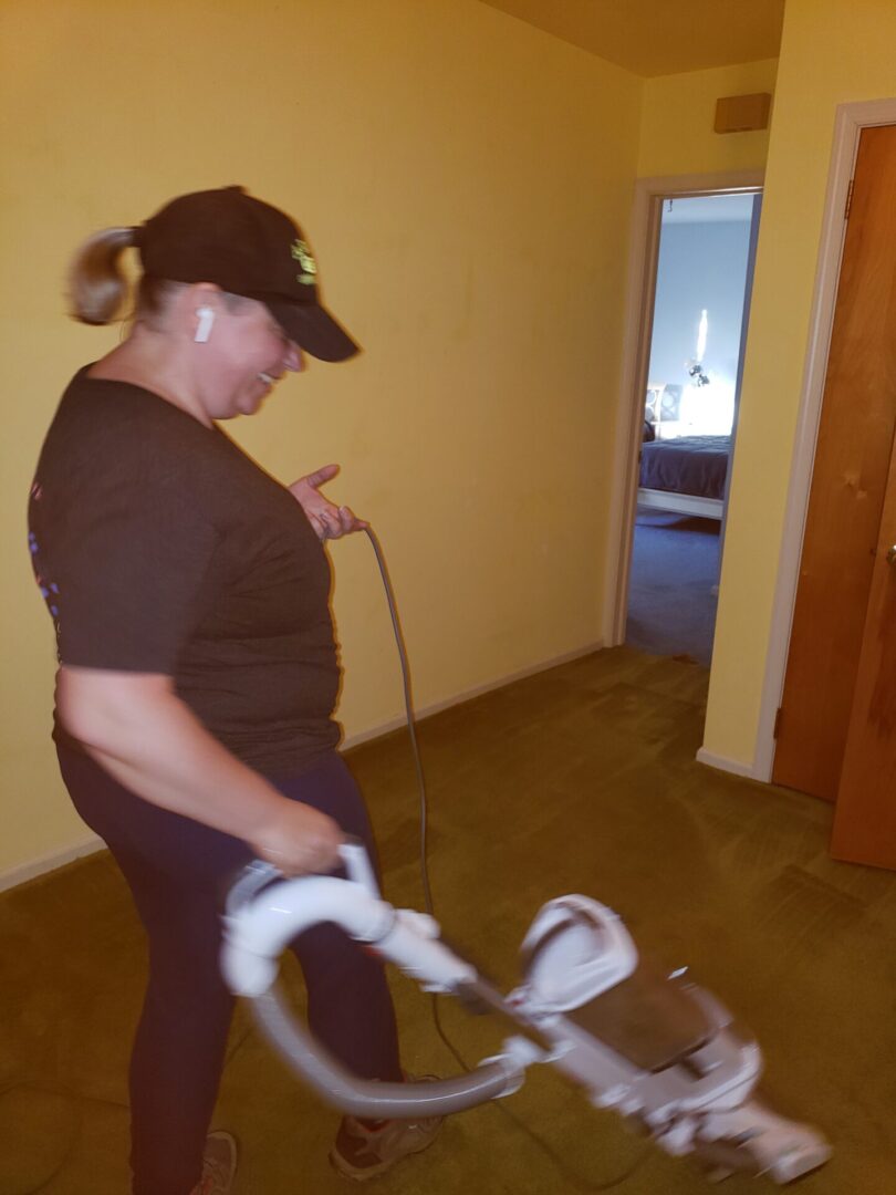 A woman vacuuming the carpets of a house
