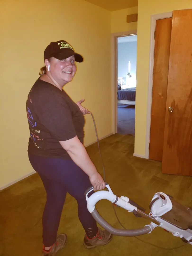 A woman wearing a cap and cleaning the house