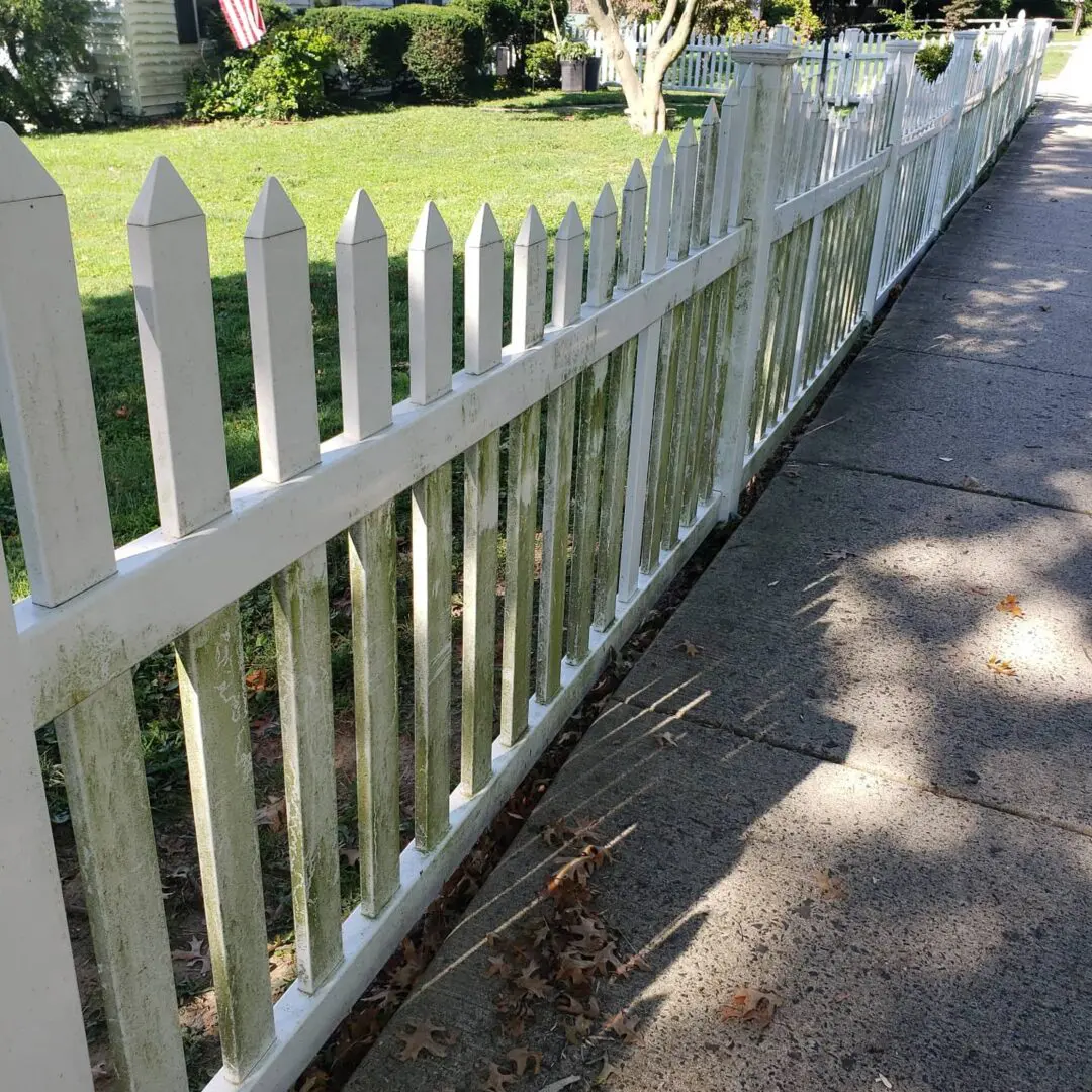 A white color fence with water damages